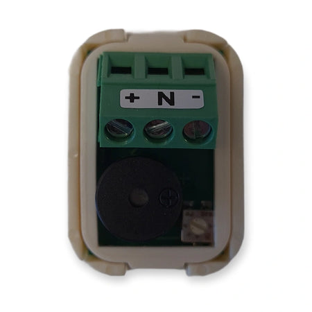Back of LiftLogic KK35 buzzer unit showing the buzzer and the green plus N minus screw terminal, on white background.